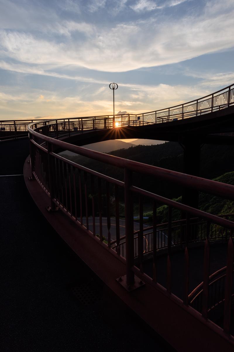 天地人橋から見た夕日に染まる空と山のシルエット写真
