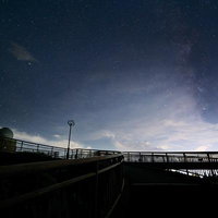星の村天文台と天地人橋のシルエット、天の川が映える夜空の写真