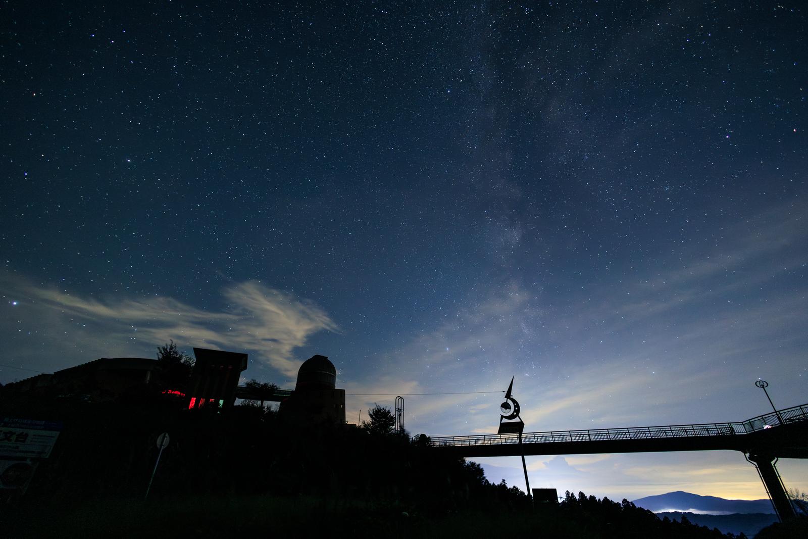 星の村天文台のシルエットと星が輝く夜空と天の川