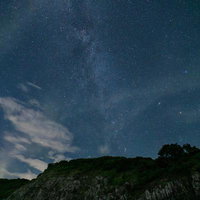 星の村天文台からの崖上に広がる天の川と星空の写真