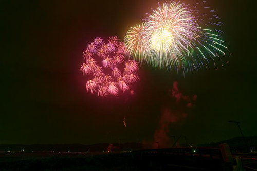 浅川町の夜空に咲く打ち上げ花火、赤やピンク、緑の閃光