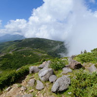 八ヶ岳連峰の天狗岳、岩が残る登山道と雲がかかる天狗ノ奥庭の写真