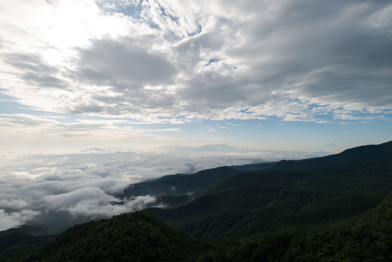 山の上に広がる白い雲海と曇り空の自然風景