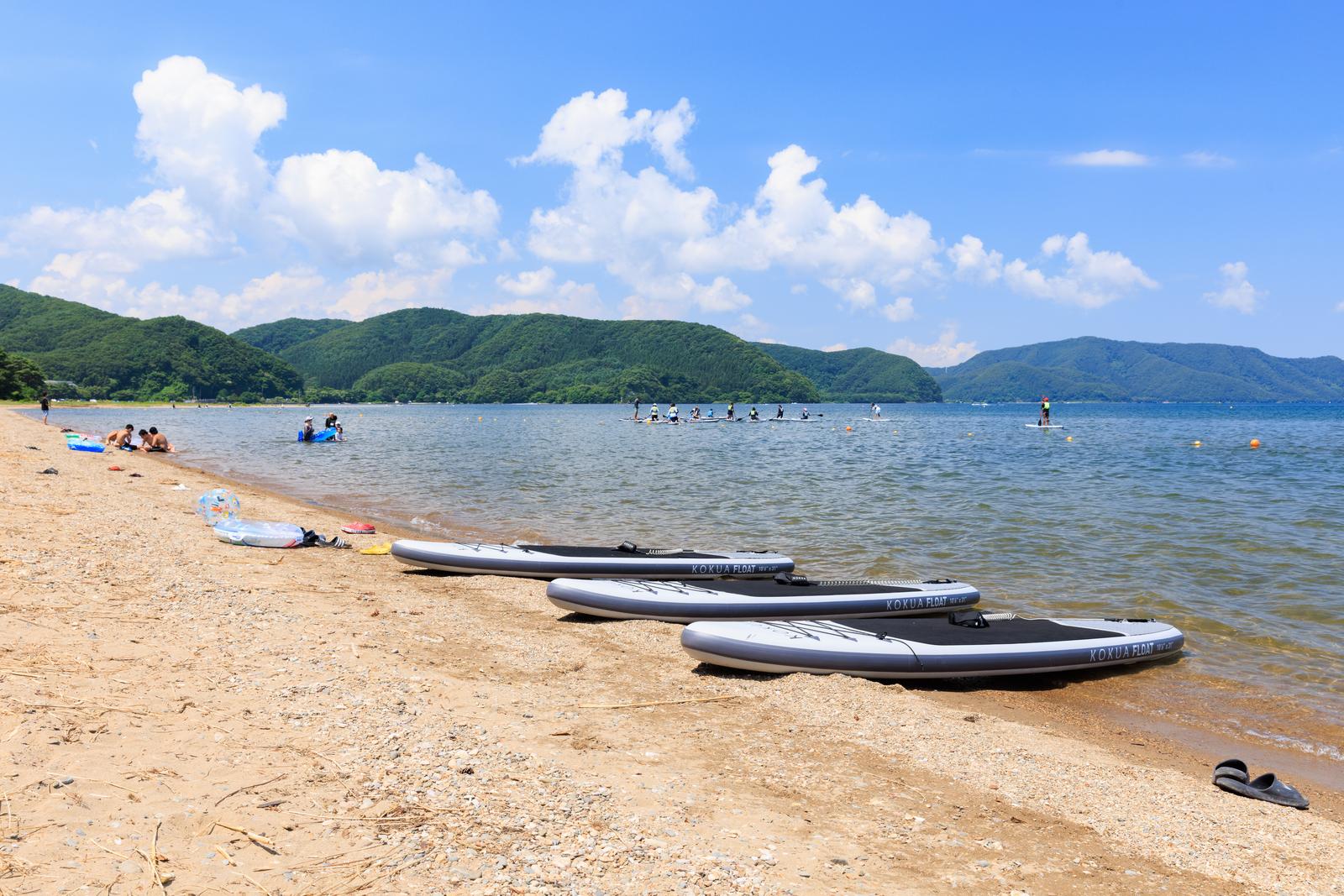 郡山市の舟津浜に並ぶSUPボードと猪苗代湖の水上風景