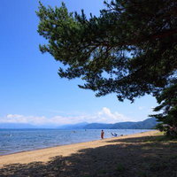 磐梯山を望む館浜のビーチアクティビティで賑わう夏景色の写真