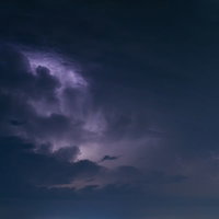 夜空に迫る雷雲と雷光が走る激しい積乱雲の写真