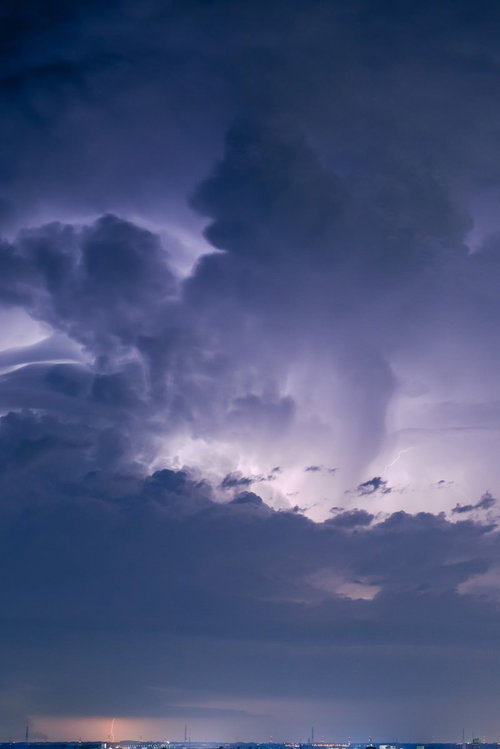 積乱雲と稲妻が街中に落ちる瞬間の雷と豪雨