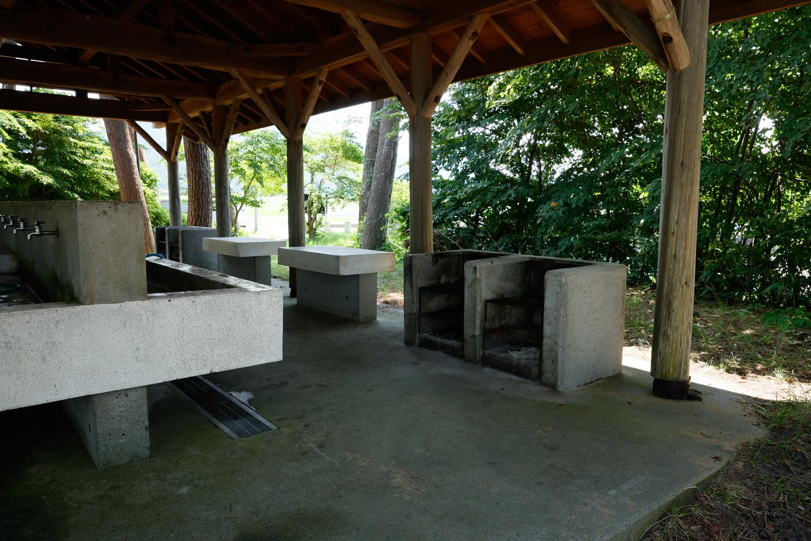 郡山市横沢浜キャンプ場の木造屋根付き炊事場に設置された複数のコンクリート調理台