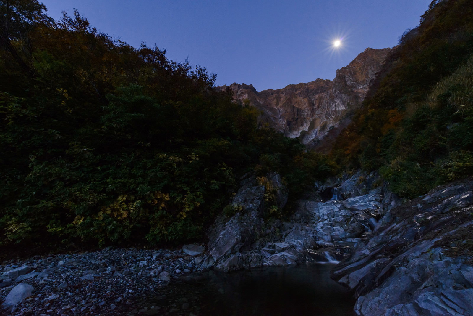 満月が照らす一ノ倉沢の夜景、岩壁と河原が月明かりで浮かび上がる