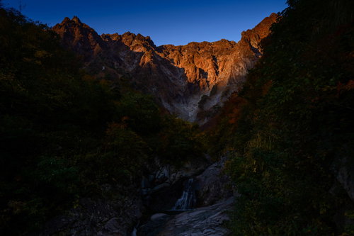 朝日を浴びて立ちはだかる一ノ倉沢の岩壁