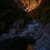 陽を待ち望む一ノ倉沢の渓谷と岩壁の景観の写真