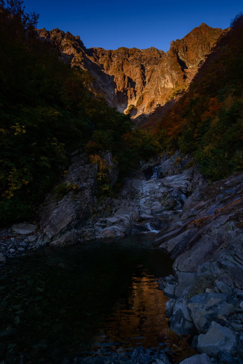陽を待ち望む一ノ倉沢の渓谷と岩壁の景観