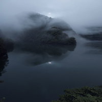 沸き立つ霧と湖面、山々から立ち昇る朝霧に包まれた南砺市の景観の写真