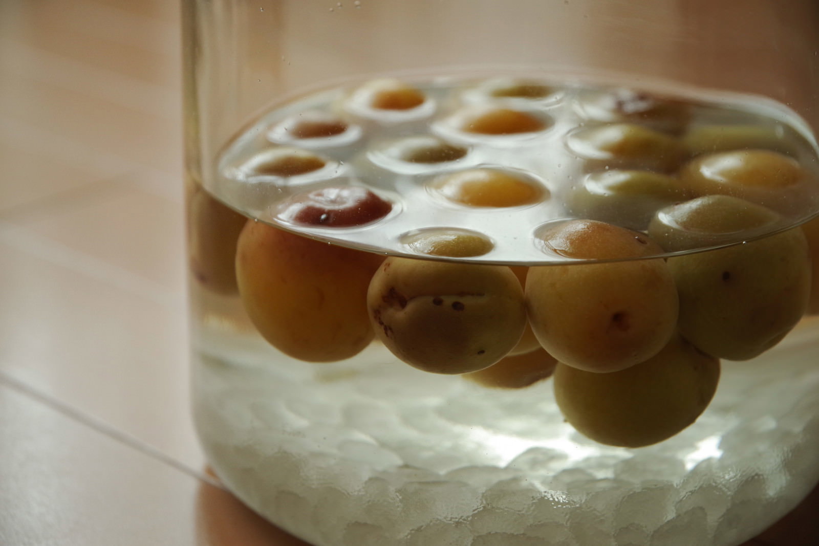 透明なガラス瓶に青梅と角砂糖を入れた手作り梅酒の仕込み