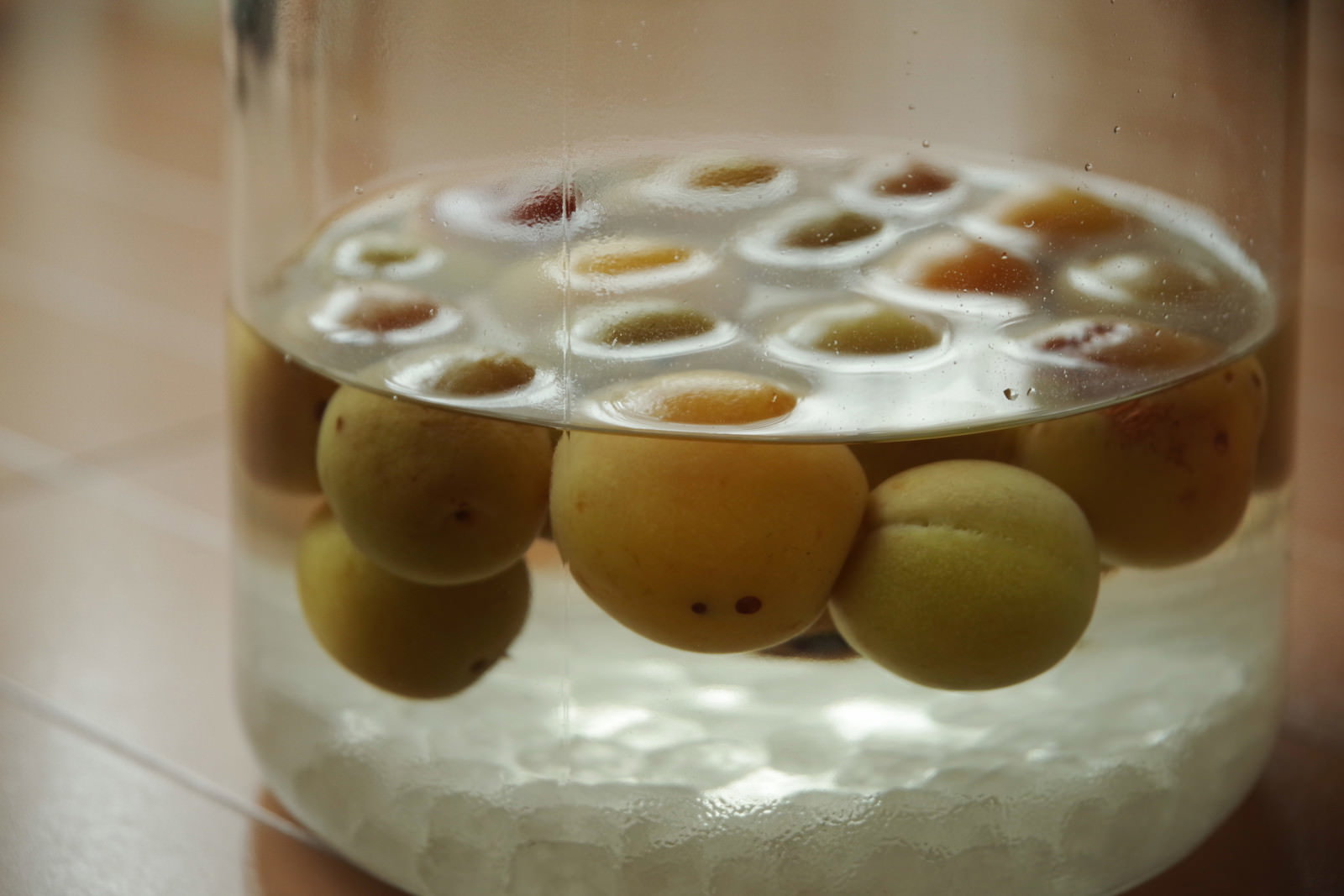 透明な保存瓶に青梅がたっぷり入った自家製梅酒と角砂糖
