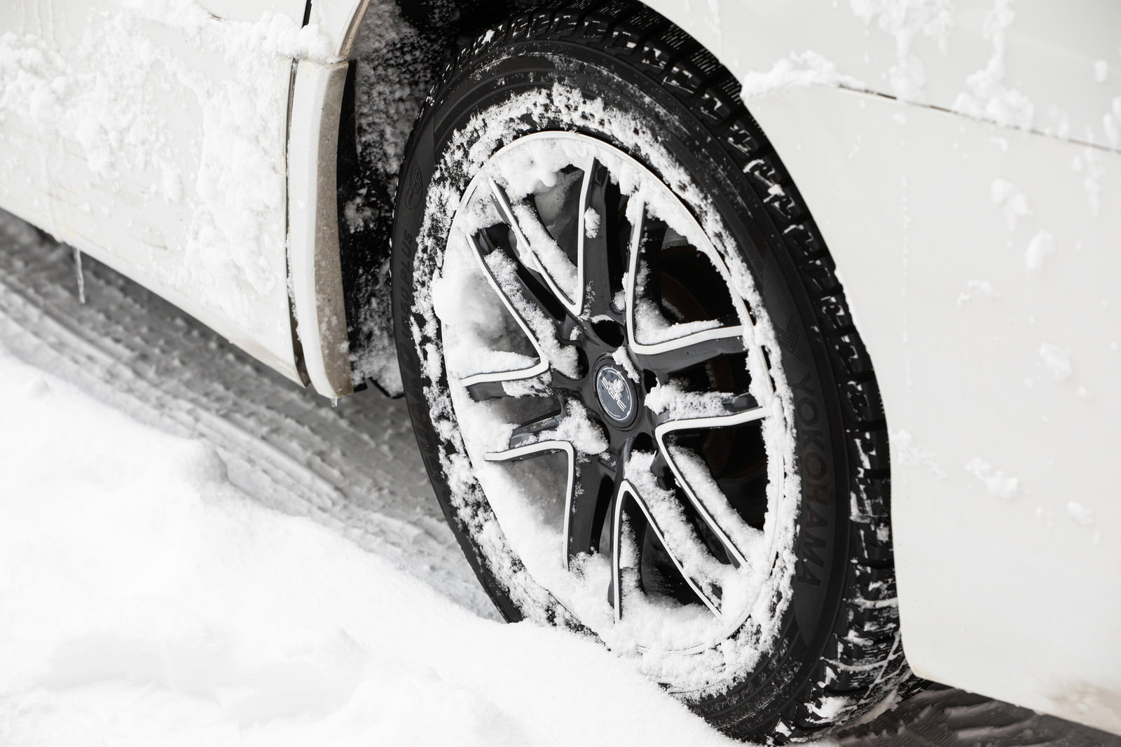 雪に覆われた道路を走行するスタッドレスタイヤのクローズアップ
