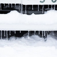 フェンスに小さいつららができる大雪の冬の写真