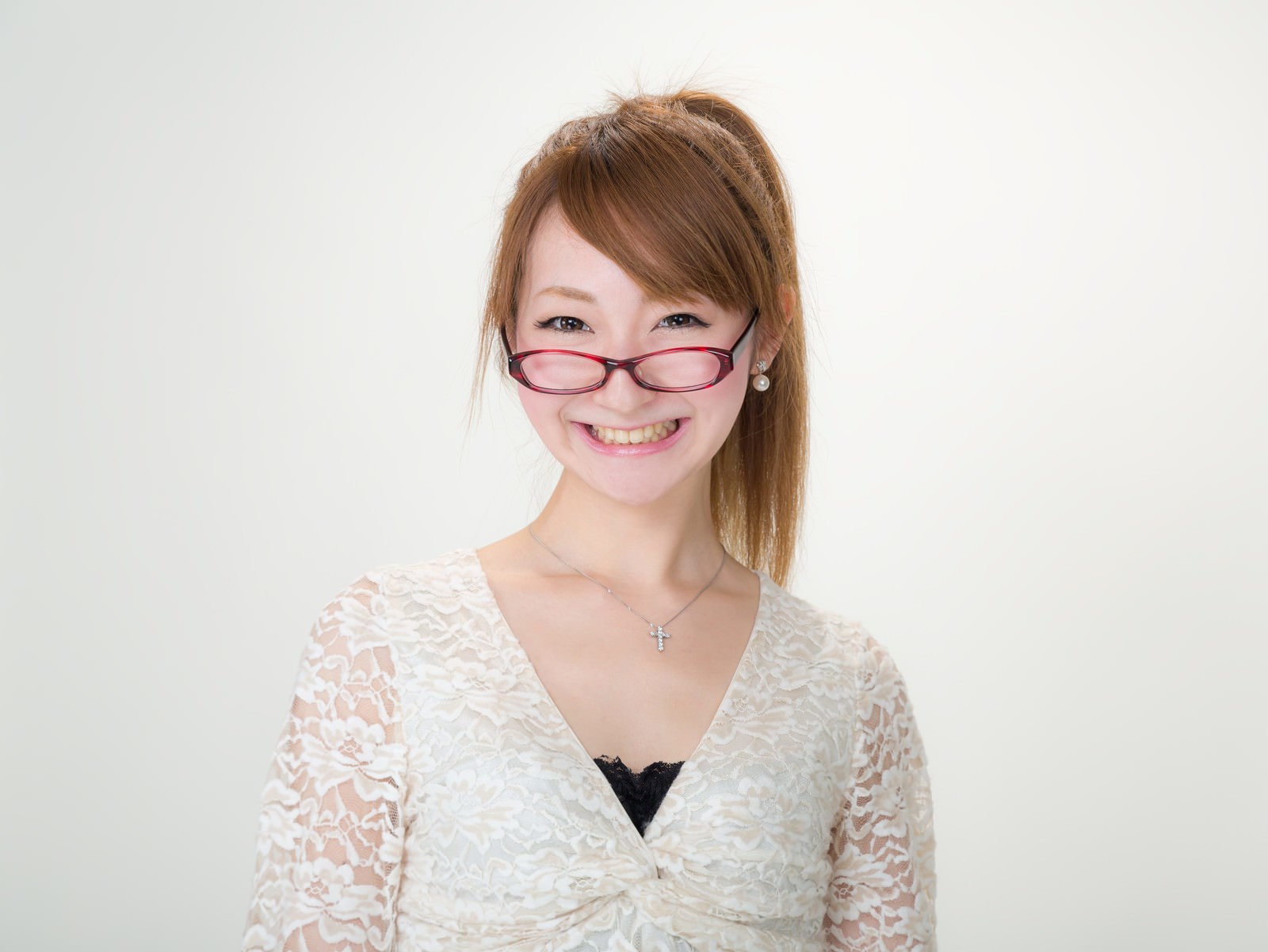 ピンク眼鏡をずらして笑う女性のポートレート写真［モデル：to-ko］