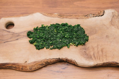 木製まな板の上で芹を細かく刻む調理風景