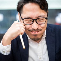 うまい料理を噛みしめるグルメライター兼上司の写真