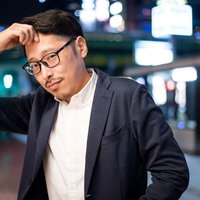 困ったなぁ、終電逃したみたい...と頭を抱える男性の写真