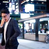 次のお店はVIP専用ですから、駅前でスマートフォンを確認するスーツ姿の男性の写真