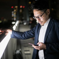 真剣な話をしているのにスマホをいじる男性の写真