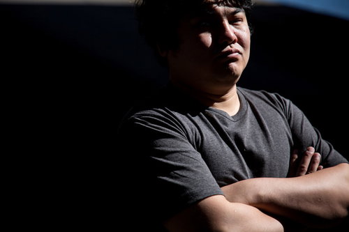 納得がいかないエンジニアの男性、腕を組んで考える