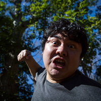 青空を背景に拳を繰り出すパンチシーンの男性の写真