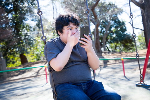 スカウトメールで年収が今の倍、ブランコの上で驚く男性