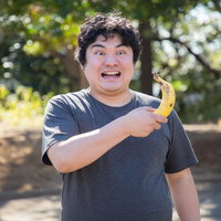 公園でバナナを持参する笑顔の男性の健康的なライフスタイルの写真