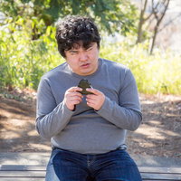 不機嫌な男性におにぎりを与えてみた瞬間の食事風景の写真