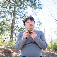 おにぎりを与えたら仲間になりたそうにこちらを見ている公園の男性の写真