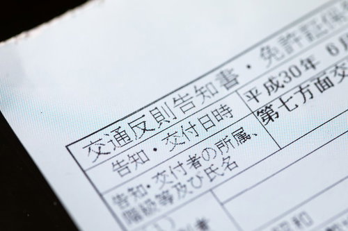 机の上に置かれた交通反則告知書とペン