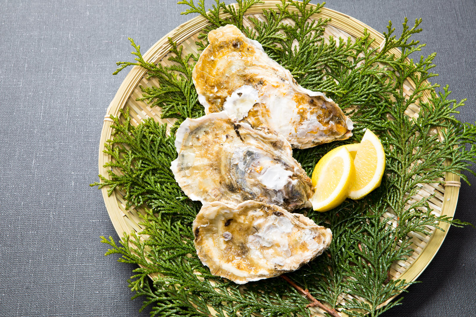 檜葉を敷いたザルに盛られた殻付きの恵比須牡蠣