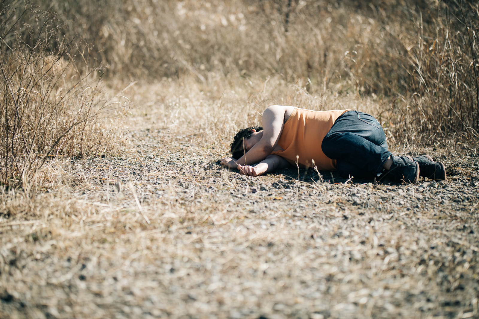 荒地に倒れ込む男性のヤムチャポーズを模したパロディ写真［モデル：段田隼人］