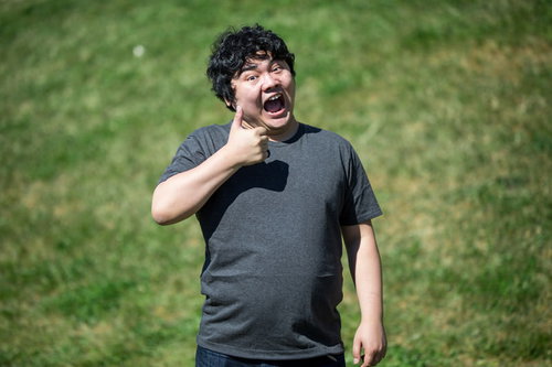 コードレビューで親指を立てて笑う男性のサムズアップポーズ