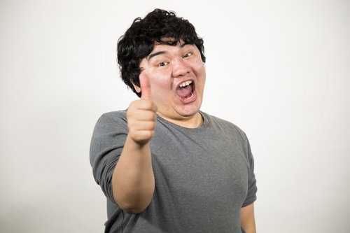 グレーのTシャツを着た男性のサムズアップ・LGTM・承認ポーズ