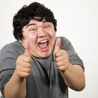黒いTシャツを着た男性の両手サムズアップの写真
