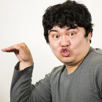 退社時に手を振るグレーTシャツの男性の挨拶の写真