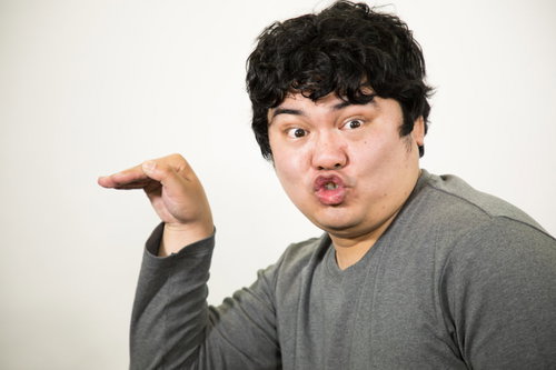 退社時に手を振るグレーTシャツの男性の挨拶