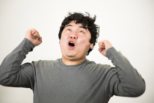 ウッホウッホ！両手を上げて叫ぶ男性の喜びと興奮