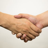 ビジネスシーンでの信頼と合意を表す男性同士の握手の写真