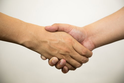 ビジネスシーンでの信頼と合意を表す男性同士の握手