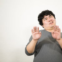 露骨に嫌がる男性の拒否ポーズ、両手を前に出して警戒や困惑を表現の写真