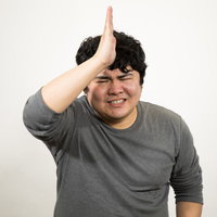 謝りながらお願いする男性のポーズ、ビジネスマンの謝罪シーンの写真