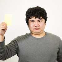 行為にイエローカードを提示する男性の警告ジェスチャーの写真