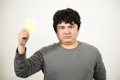 行為にイエローカードを提示する男性の警告ジェスチャー
