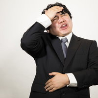 頭とお腹が痛いので帰ります。会社員の男性の写真
