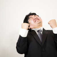 ガッツポーズをして喜ぶ男性ビジネスマンの成功の写真